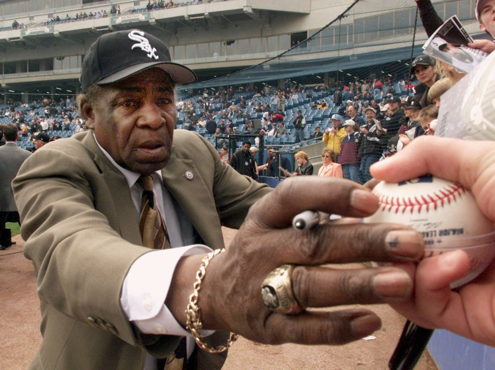 Chicago White Sox legend Orestes “Minnie” Minoso signs autographs before to the White Sox’ home opener against the Detroit Tigers in 2001.
