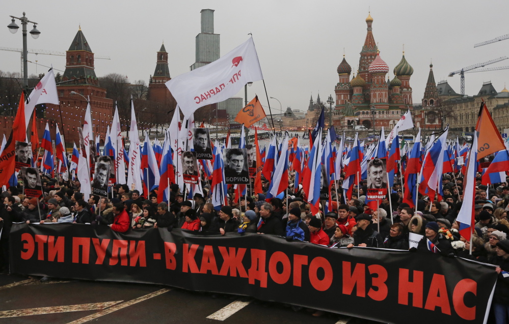 A large crowd in central Moscow, fronted by a banner reading “those bullets for everyone of us,” march together as a protest of the death of liberal opposition leader Boris Nemtsov who was gunned down on Friday near the Kremlin.