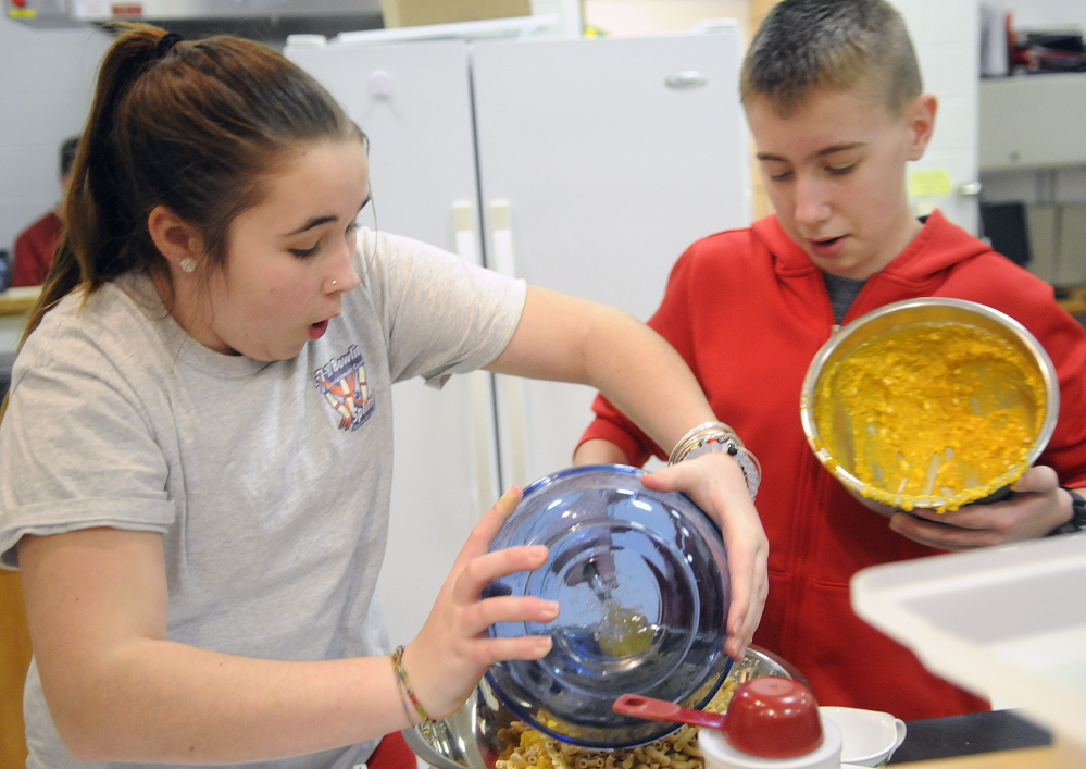 Sarah Cook-Wheeler and Devin Young mix macaroni and cheese after class at Cony High School in Augusta. The students are learning how to prepare healthy meals as part of the Food Matters program.