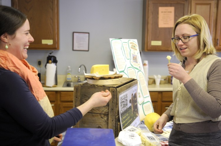 Kate Harris, right, samples Guernsey cheese kurd from Anne Trenholm’s farm, Wholesome Holmstead of Winthrop, during a community supported agriculture exhibition in Hallowell on Sunday. Customers had an opportunity to meet a variety of local farmers at the event. Wholesome Holmstead raises Angus beef cattle and milk-fed pork in addition to dairy products such as cheese.