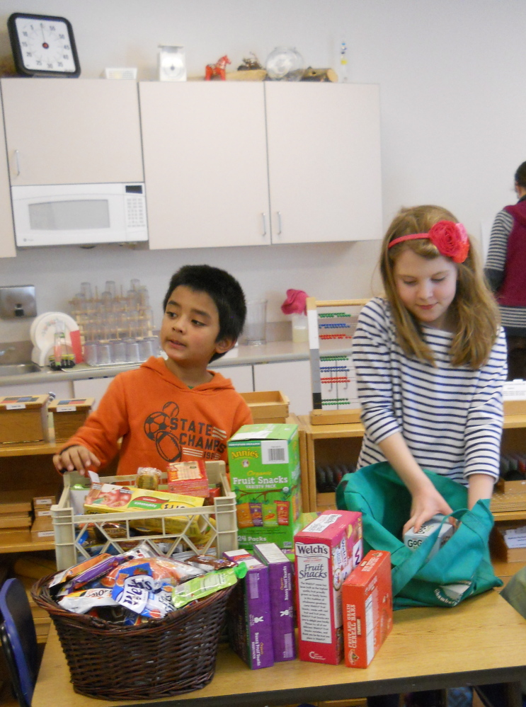 Share Your Snack Week was held recently at the Kennebec Montessori School in Fairfield. Students were invited to bring in an extra snack to share with children at the Mid-Maine Homeless Shelter. From left, are elementary students Savya Acharya and Kate Rice as they organize the donations for delivery.