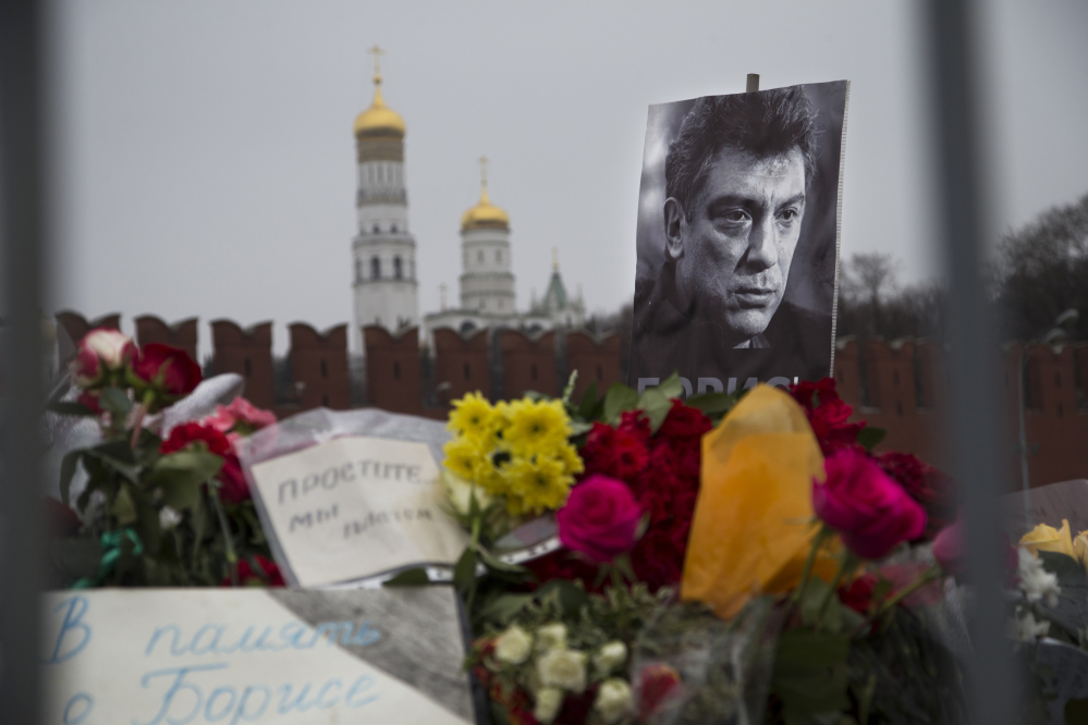 Flowers and a condolence message that reads “In memory of Boris” are placed with a portrait of Boris Nemtsov, a charismatic Russian opposition leader and sharp critic of President Vladimir Putin, at the site where Nemtsov was gunned down near the Kremlin, against a backdrop of the Kremlin Wall, in Moscow, Russia, Monday.