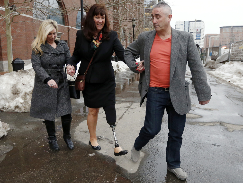 Boston Marathon bombing survivors Heather Abbott, left, and Karen Rand, center, are escorted from federal court, Wednesday, March 4, 2015, in Boston, after the first day of the federal death penalty trial of Boston Marathon bombing suspect Dzhokhar Tsarnaev. Tsarnaev is charged with conspiring with his brother to place two bombs near the marathon finish line in April 2013, killing three and injuring 260 people. (AP Photo/Michael Dwyer)