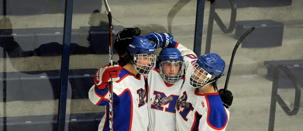 Messalonskee High School’s Jake Dexter (7) celebrates with teammates Jared Cunningham (19), center and Brandon Nale (10) right after scoring on Winslow High School goalie Andrew Beals (35) last week. The Eagles play Gorham on Saturday for the Class B championship.