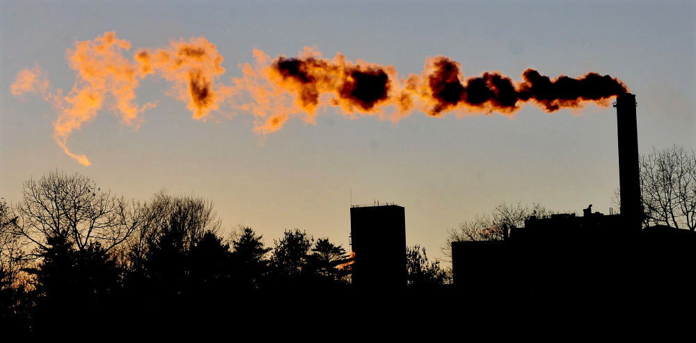The setting sun fills the blowing smoke with color coming from the Sappi paper mill in Skowhegan in November 2014.