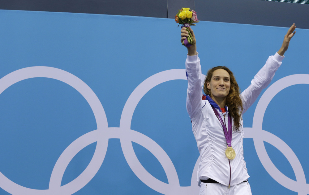 In this Sunday, July 29, 2012 file photo France’s Camille Muffat celebrates with her gold medal for the women’s 400-meter freestyle swimming final at the Aquatics Centre in the Olympic Park during the 2012 Summer Olympics in London.
