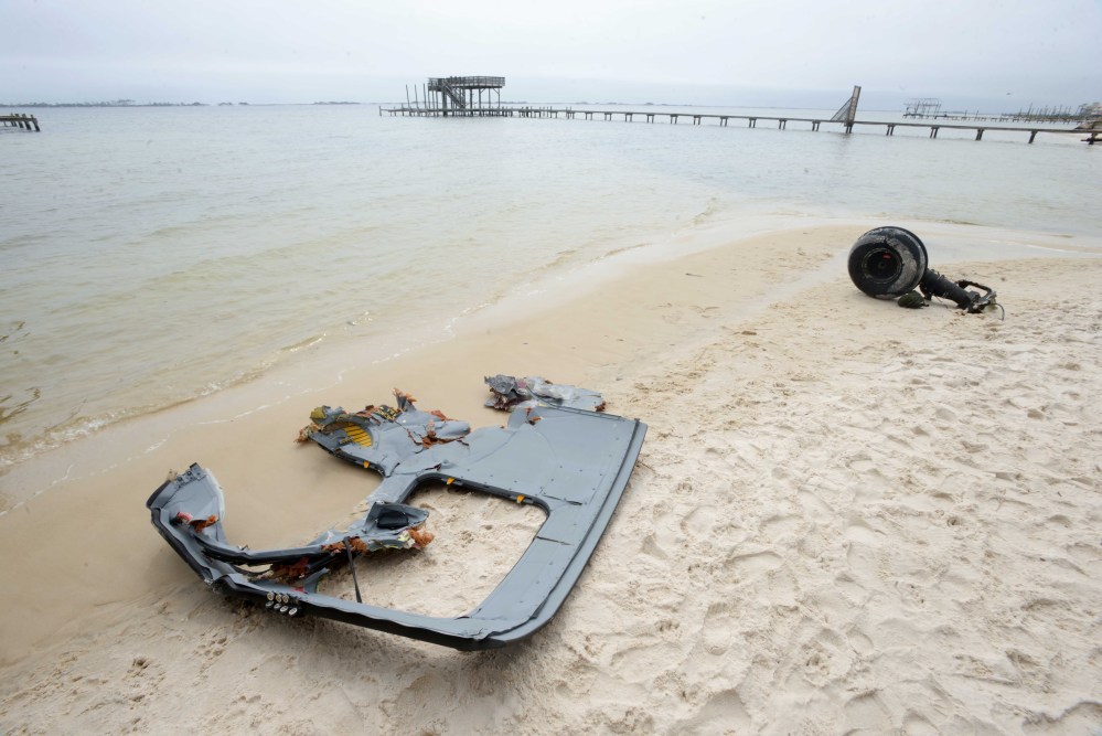 A wheel and pieces of fuselage from an Army Black Hawk helicopter lie along the shoreline of Santa Rosa Sound near Navarre, Fla., on Wednesday. Search and rescue crews combed the water looking for service members who were on the aircraft when it went down in the area Tuesday evening.