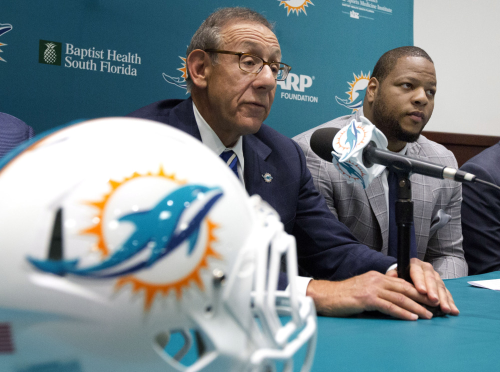 Miami Dolphins owner, Stephen Ross, left, and his newest player, Ndamukong Suh, talk Wednesday in Davie, Fla.. Suh signed a $114 million, six-year deal with the Dolphins.