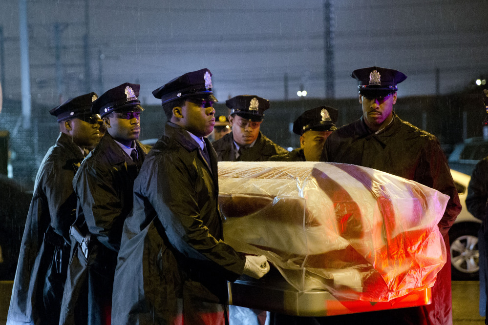 The remains of Philadelphia Police Officer Robert Wilson III are transferred to a horse drawn hearse during a winter rainstorm on Saturday in Philadelphia. Wilson was shot and killed March 5 after he and his partner exchanged gunfire with two suspects trying to rob a video game store.