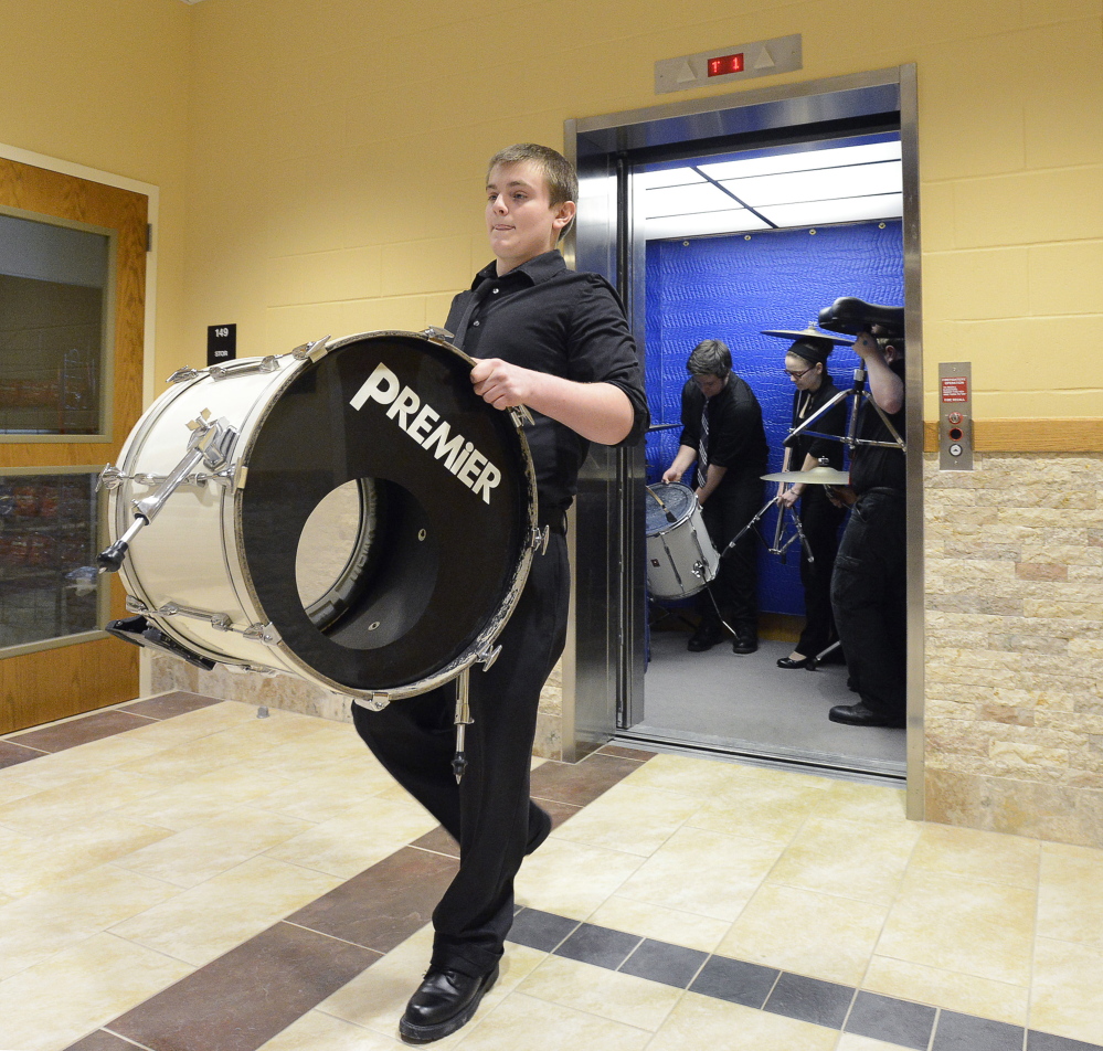 SOUTH PORTLAND, ME - MARCH 14: Ellsworth HS drummer Cameron Petros, a sophomore, carries one of his drums from a crowded elevator to the stage as they get ready to compete at the 2015 MMEA High School Instrumental Music Jazz Festival at South Portland HS. (Photo by John Patriquin/Staff Photographer)