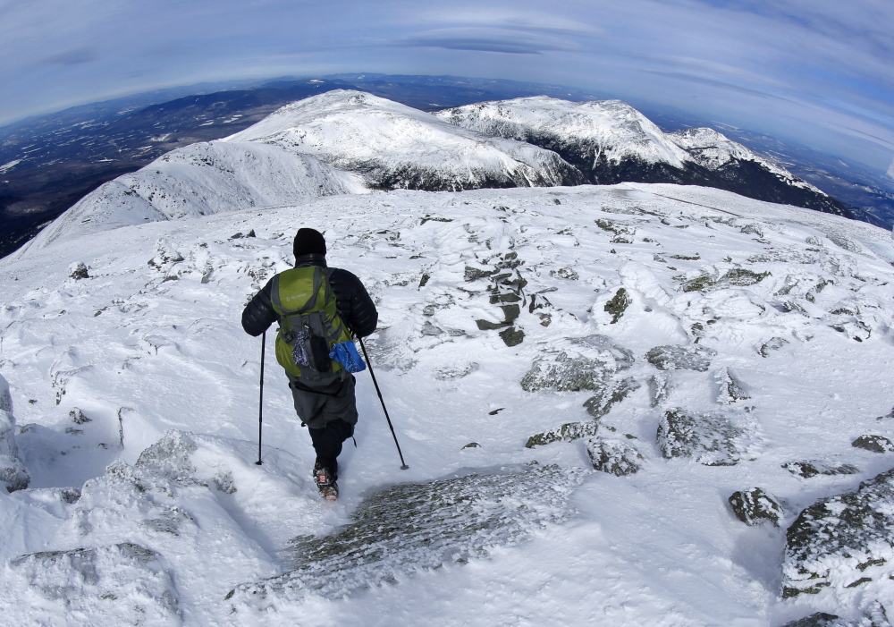 A hiker leaves the summit of Mount Washington last week. The snow-covered peaks of the northern Presidential Range can be seen in the distance.