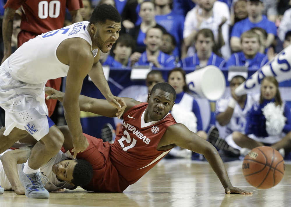 Kentucky guard Andrew Harrison (5) and Arkansas guard Manuale Watkins (21) chase a loose ball during the second half of the Southeastern Conference championship game Sunday in Nashville, Tenn. The Wildcats are the heavy favorites to win the NCAA tournament.