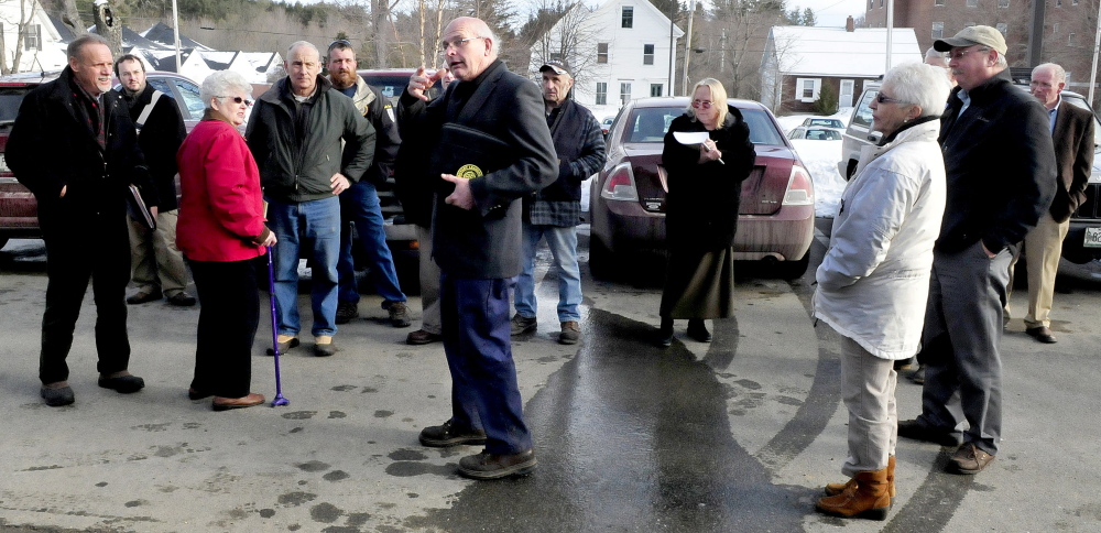 Farmington Planning Board Chairman Clayton King, center, directs other board members and interested citizens to where a tractor-trailer will negotiate a turn to deliver wood chips to a proposed wood boiler system on the University of Maine campus on Monday.