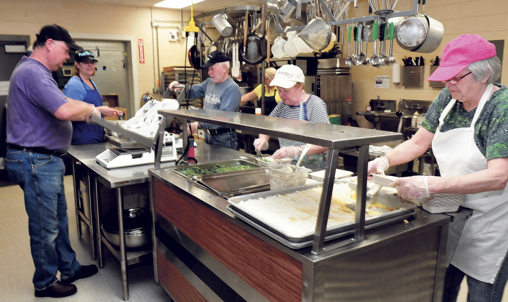 Volunteers at the Muskie Center in Waterville prepare dinners for the Meals on Wheels program on Wednesday. From left are John Veilleux, Victoria Veilleux, Vaughn Tuttle, Rita Tuttle and Cheryl Gulliver.