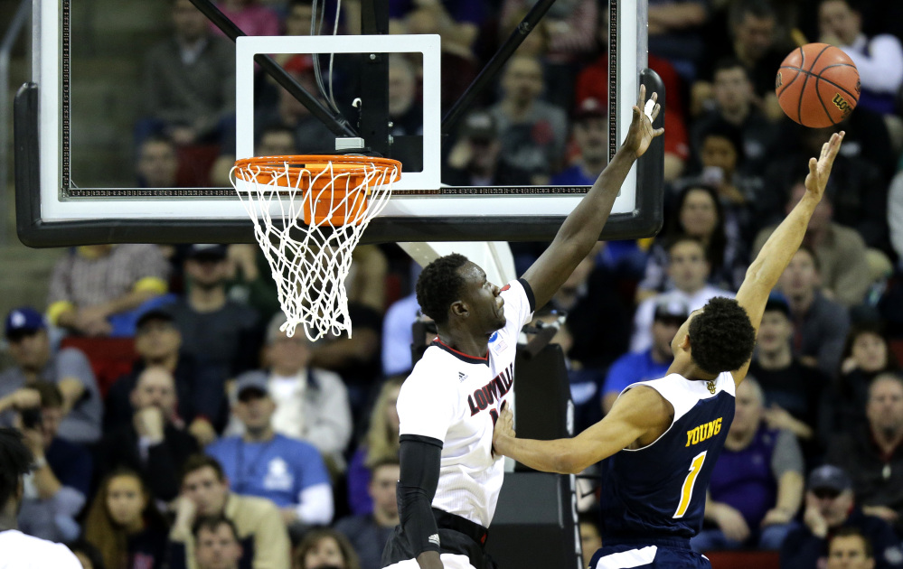 Louisville’s Mangok Mathiang, left, tries to block a shot by UC Irvine’s Alex Young, right, in the second half Friday of an NCAA tournament game in Seattle. Louisville beat UC Irvine 57-55.