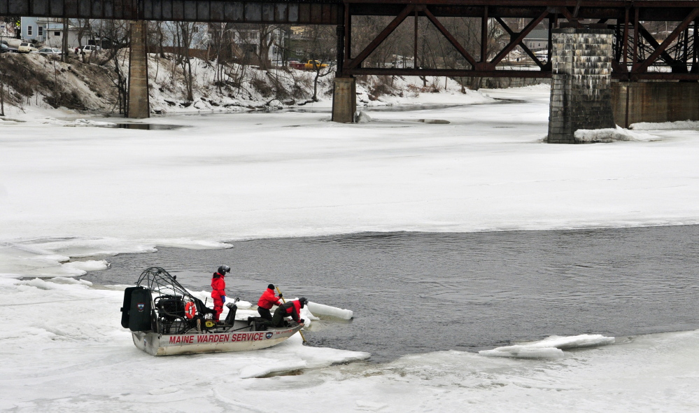 Wardens on an airboat search the Kennebec River on Saturday for a woman who disappeared under the ice between the Calumet Bridge at Old Fort Western and the railroad trestle in Augusta.