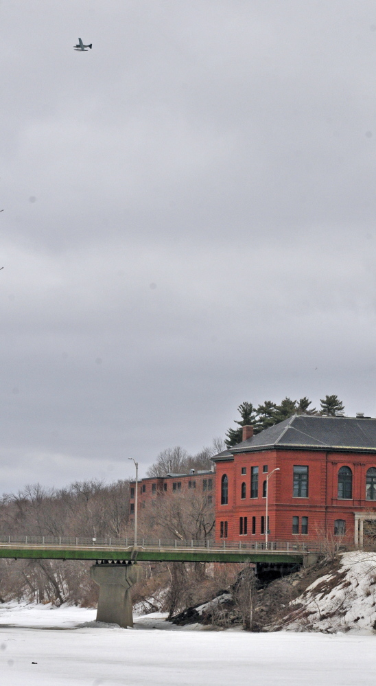 A Marine Patrol plane flies above the Kennebec River during a search for a woman who disappeared Saturday under the ice of the Kennebec River north of the Calumet Bridge at Old Fort Western in Augusta.