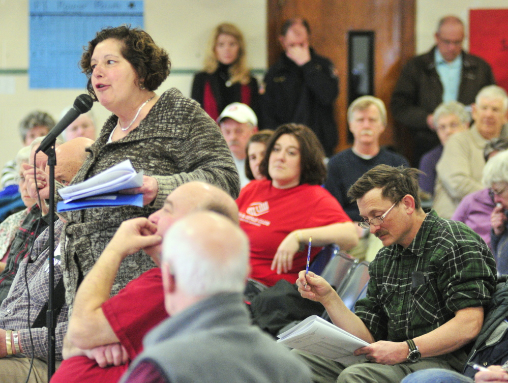 Gardiner Public Library Director Anne Davis, left, answers a question Saturday about Pittston’s funding the library from Tim Lawrence, right, during the Pittston Town Meeting at the Pittston Consolidated School. Voters approved funding for the library.