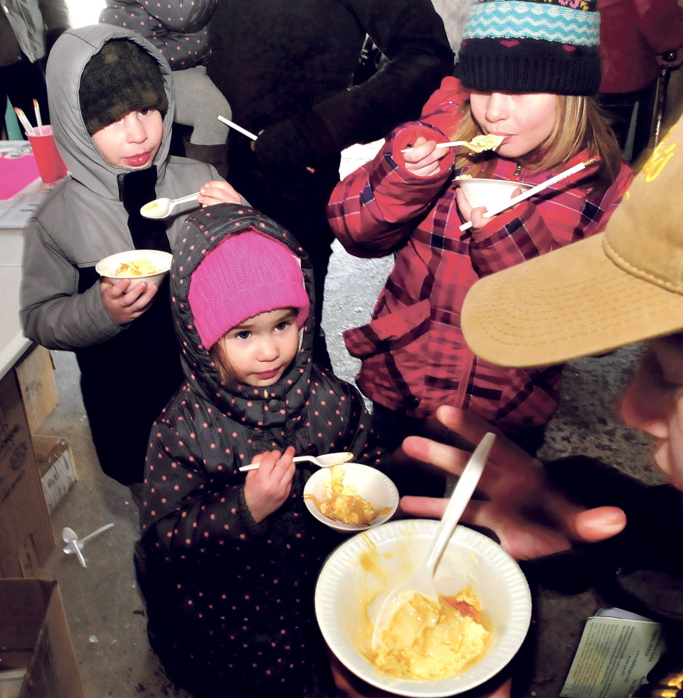 The MacArthur children enjoy ice cream smothered with maple syrup Sunday during the Maine Maple Sunday event. From left, Gaige, Pyper and Vaydah eat the treat at the Smith Brothers Maple operation in Skowhegan.