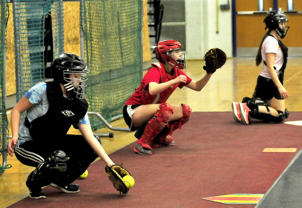 Messalonskee High School catchers practice with pitchers on the first day of practice Monday in Oakland. From left are Kaylee Burbank, Taylor Easler and Dakota Bragg.