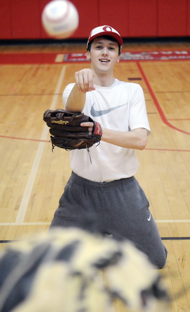 Staff photo by Andy Molloy 
 Cony High School baseball pitcher Tom Foster tosses a ball during a practice Monday afternoon. Pitchers and catchers began practicing Monday.