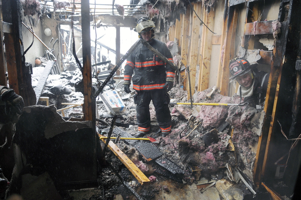 A firefighter inspects the remains of an apartment building Feb. 5 on Highland Avenue in Gardiner after a fire there displaced about 30 people.