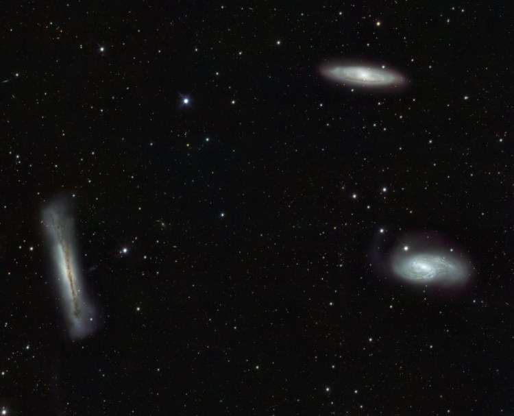 The Leo Triplet — NGC 3628, left; M66, bottom right; and M65, top right — three large spiral galaxies in the constellation Leo.