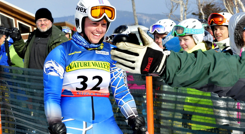 Colby College’s Sierra Leavitt gets a high five from Stacy Patrick after her race during the U.S. Alpine Championships on Thursday at Sugarloaf Mountain.