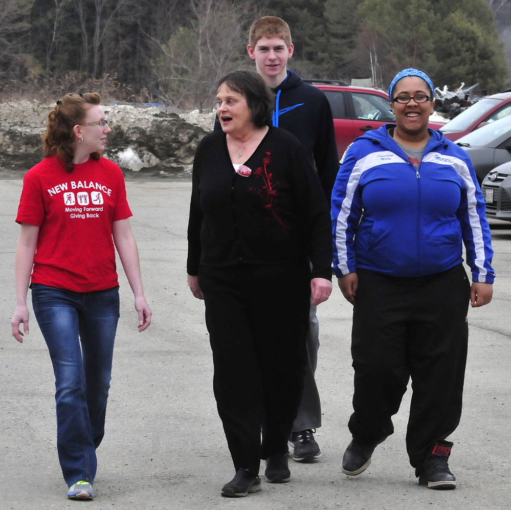 In an effort to motivate people to get exercise, students from Upper Kennebec Valley Memorial High School, New Balance Athletic Shoe Inc. and Bingham Area Health Center have distributed pedometers and vouchers for sneakers. Going for a walk and trying out the pedometer she received Thursday, Rose Mary Henderson, center, speaks with Ashley Brooks of New Balance and students Cody Laweryson and Courtney Mills.