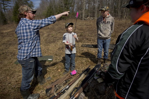 Travis McLeod of Halifax, Nova Scotia, shows Brady Whitman, 9, also of Halifax, how to balance an arrow on his fingertip during a "Hoot and Shoot," a Youth Turkey Hunting Camp put on last April by members of the National Wild Turkey Federation. (Press Herald photo by Gabe Souza)
