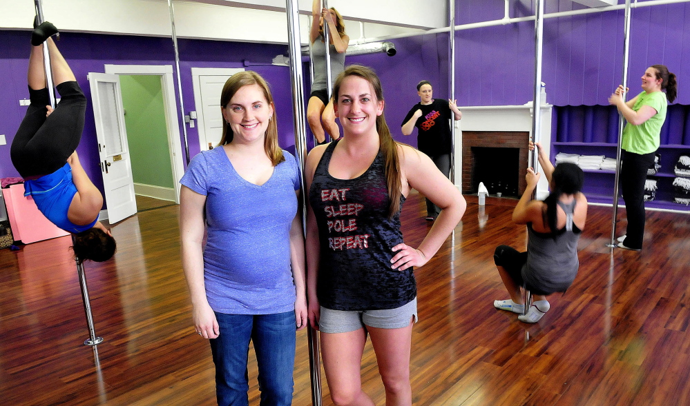 Empower co-owners and sisters Kate Poulin, left, and Heather MacKenzie pose as students practice a pole exercise at the Waterville business. Students from left are Margo MacKenzie, Penny Davis, Courtney Clark, Sarah Golden and Elizabeth Jensen.