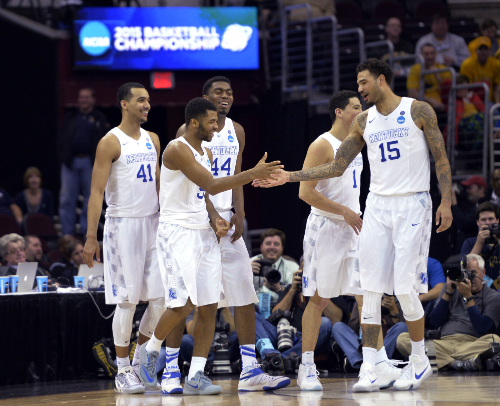 Kentucky’s Andrew Harrison is congratulated by Willie Cauley-Stein (15) during the second half Thursday against West Virginia in the NCAA men’s tournament regional semifinals in Cleveland.