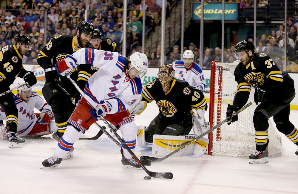 New York Rangers right wing Mats Zuccarello, 36, looks to pass in front of the goal as Boston Bruins goalie Tuukka Rask, 40, defenseman Zdeno Chara, 33, and center Patrice Bergeron, 37, keep an eye on the puck during the first period Saturday in Boston.