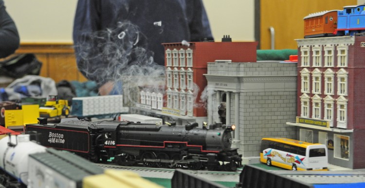 Smoke puffs from a steam engine as it runs around a model layout during the Maine3Railers model railroad show on Saturday at the Elks Club in Augusta.