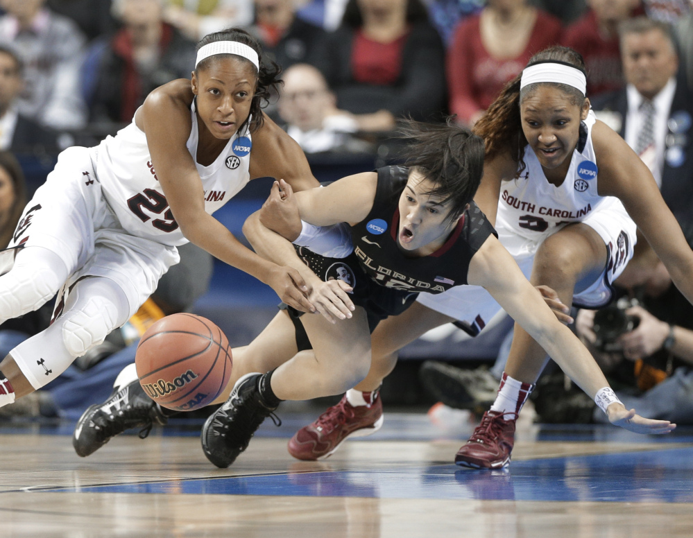 Florida State’s Leticia Romero, center, battles South Carolina’s Tiffany Mitchell, left, and Asia Dozier, for the ball in the first half of Sunday’s Greensboro Regional final at Greensboro, N.C.