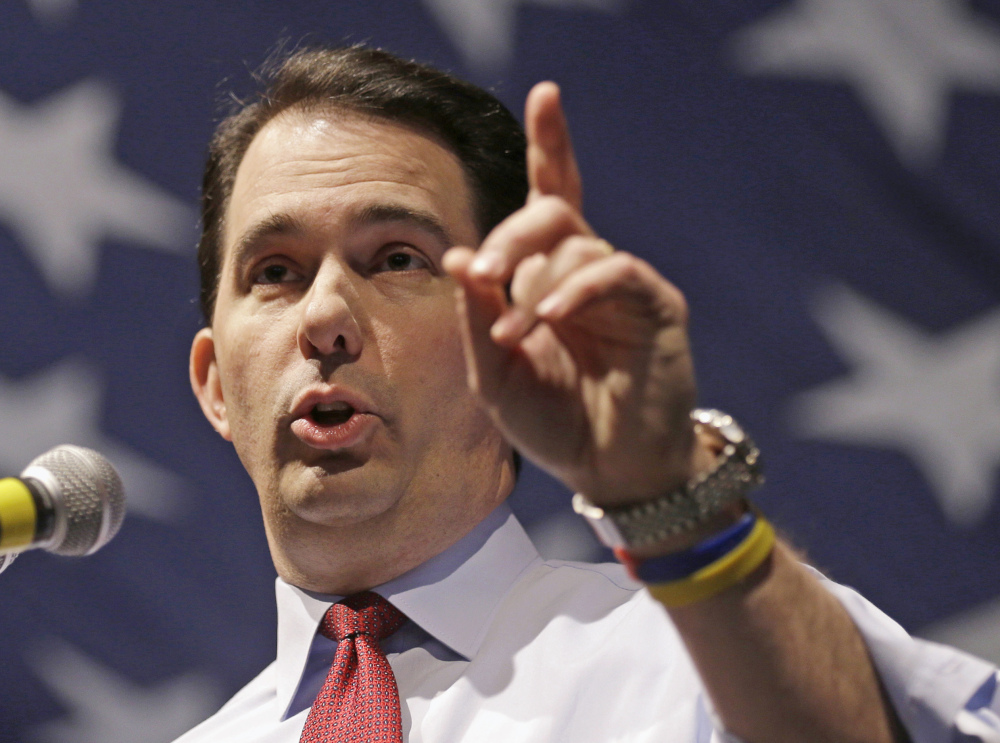 Wisconsin Republican Gov. Scott Walker, who signed right-to-work legislation in Wisconsin on Monday, put his defiance of organized labor even more at the center of his potential presidential campaign.