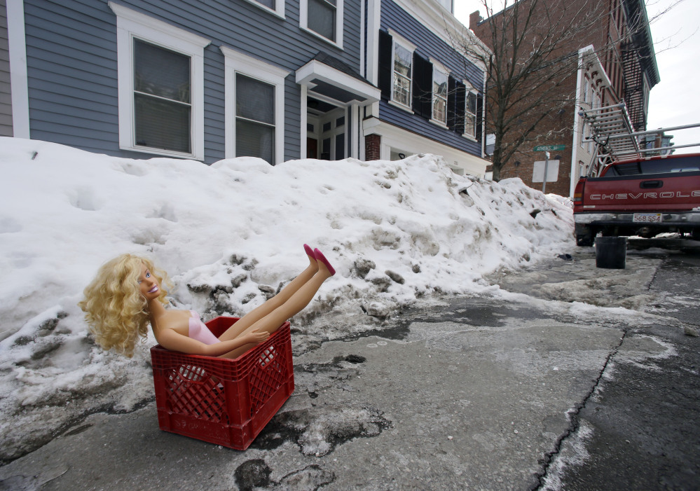 A fashion doll in a milk crate saves a parking space on a residential street in South Boston, preserving the unwritten rule: If you shoveled it out, it’s yours.