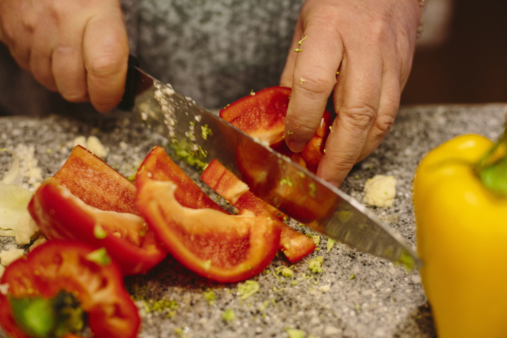Julie Johnson slices red pepper for a roast vegetable dish. Whitney Hayward/Staff Photographer