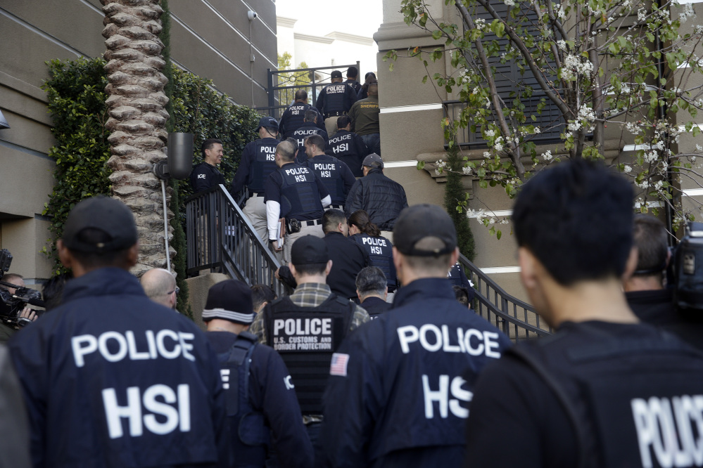 Federal agents enter an upscale apartment complex Tuesday in Irvine, Calif., where authorities say a birth tourism business charged pregnant women $50,000 for lodging, food and transportation. The key draw for travelers is that the United States offers birthright citizenship.