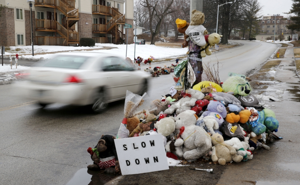 A car passes a memorial for Michael Brown, who was shot and killed by Ferguson, Mo., Police Officer Darren Wilson last summer, Tuesday, in Ferguson.