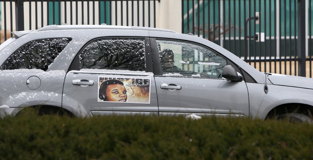 Members of the Brown family, including his mother, Lesley McSpadden, leave the St. Louis FBI offices in a car decorated with Michael Brown’s photograph after meeting with federal officials on Wednesday. The Justice Department won’t prosecute a former Ferguson, Missouri, police officer in the shooting death of Michael Brown, but has faulted the city and its law enforcement for racial bias and unconstitutional practices.