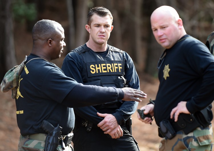 Wilson County sheriff's deputies investigate an area near Interstate 95  in Wilson, N.C., on Monday. Armed robbers hijacked an armored truck, tied up the two guards and disappeared with 275 pounds of gold bars.
Associated Press/The Wilson Times, Brad Coville