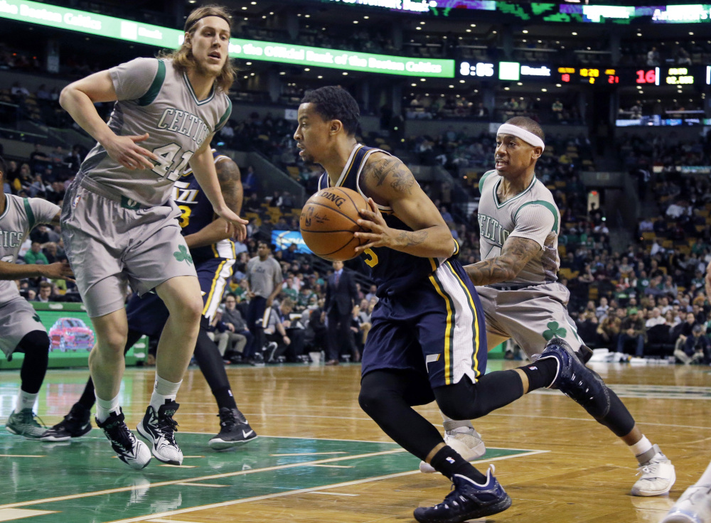 Utah Jazz guard Trey Burke drives for the hoop against Celtics guard Isaiah Thomas, right, and Celtics center Kelly Olynyk during the first half of Wednesday night’s game in Boston.