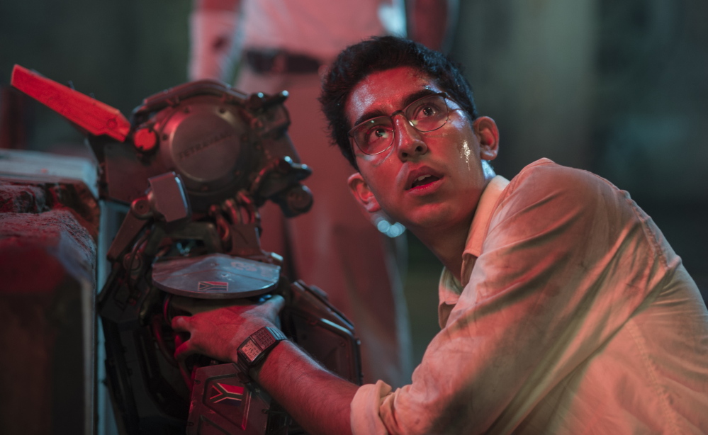 Dev Patel appears worried in a scene from “Chappie,” a film about a police robot that learns how to think and feel.