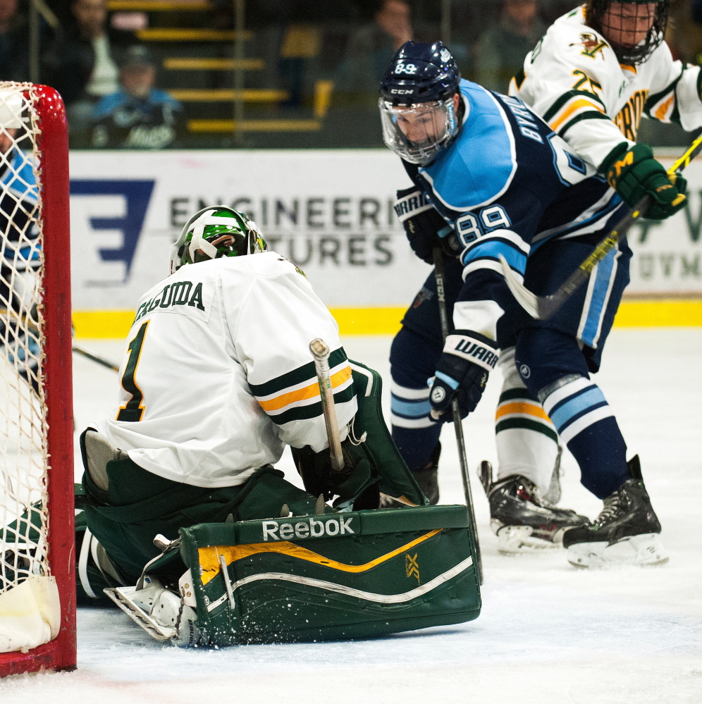 Maine’s Blaine Byron looks for a rebound in front of Vermont goalie Mike Santaguida during Game 3 of a Hockey East playoff series Sunday night in Burlington, Vermont. Vermont eliminated the Black Bears with a 3-2 overtime victory.