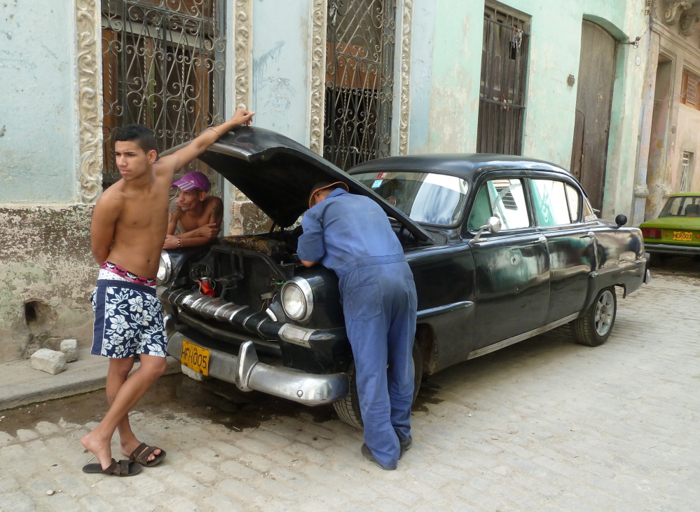 Men work on a car near Adath Israel, the only Orthodox Jewish synagogue remaining in Cuba, in 2013. Cuba has fewer than 1,500 Jews today, although as many as 24,000 lived there in the 1920s, according to various sources.
