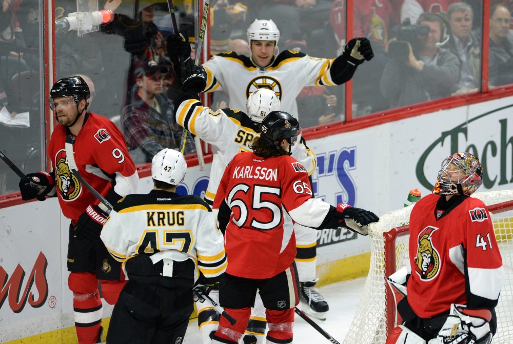 Ottawa Senators, left to right, Milan Michalek, Erik Karlsson and Craig Anderson react to a goal by the Bruins’ Ryan Spooner, center, as he celebrates with teammate Milan Lucic during the second period Tuesday night in Ottawa, Ontario.