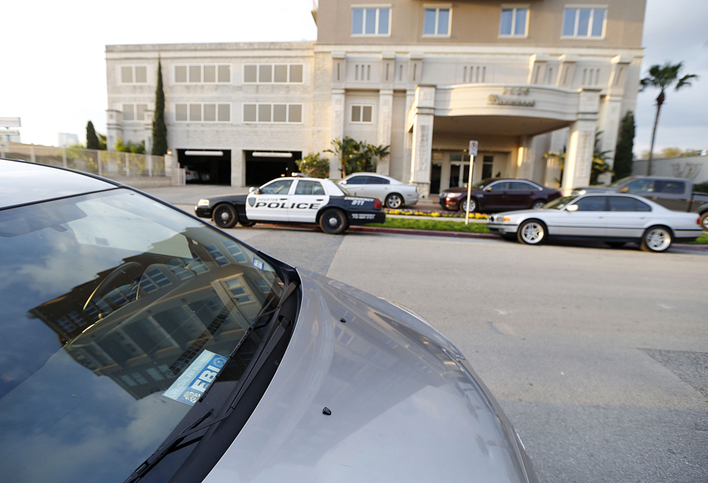 Police cars and a vehicle with a Federal Bureau of Investigation placard sit outside the building where Robert Durst owns some condominiums Tuesday in Houston.
