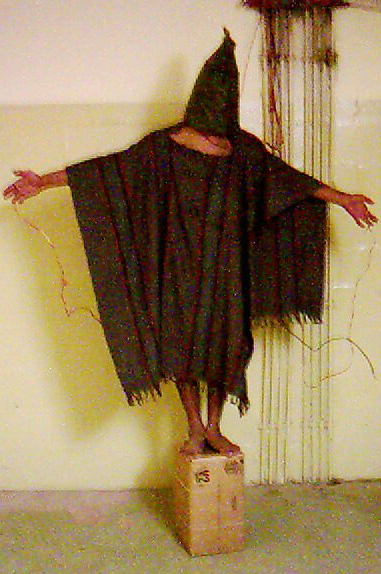 A 2003 image shows a detainee at the Abu Ghraib prison in Baghdad, Iraq, with wires attached to him.