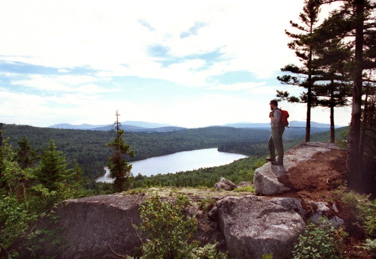 A Maine forester overlooks Sing Sing Pond along the Turtle Ridge Trail in the Nahmakanta Lake region between Moosehead Lake and Baxter State Park. Under Gov. Paul LePage’s proposed timber-harvesting changes for state-owned forestlands, such as the 44,000 acres that make up Nahmakanta Public Reserved Lands, critics fear a dramatic shift in the multiple-use philosophy that has guided management for decades. LePage officials insist the “underlying, guiding” principles regarding harvesting on public land won’t change.